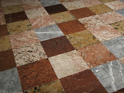 Bodenbelag aus marmorierten Fliesen in verschiedenen Farben und Mustern.